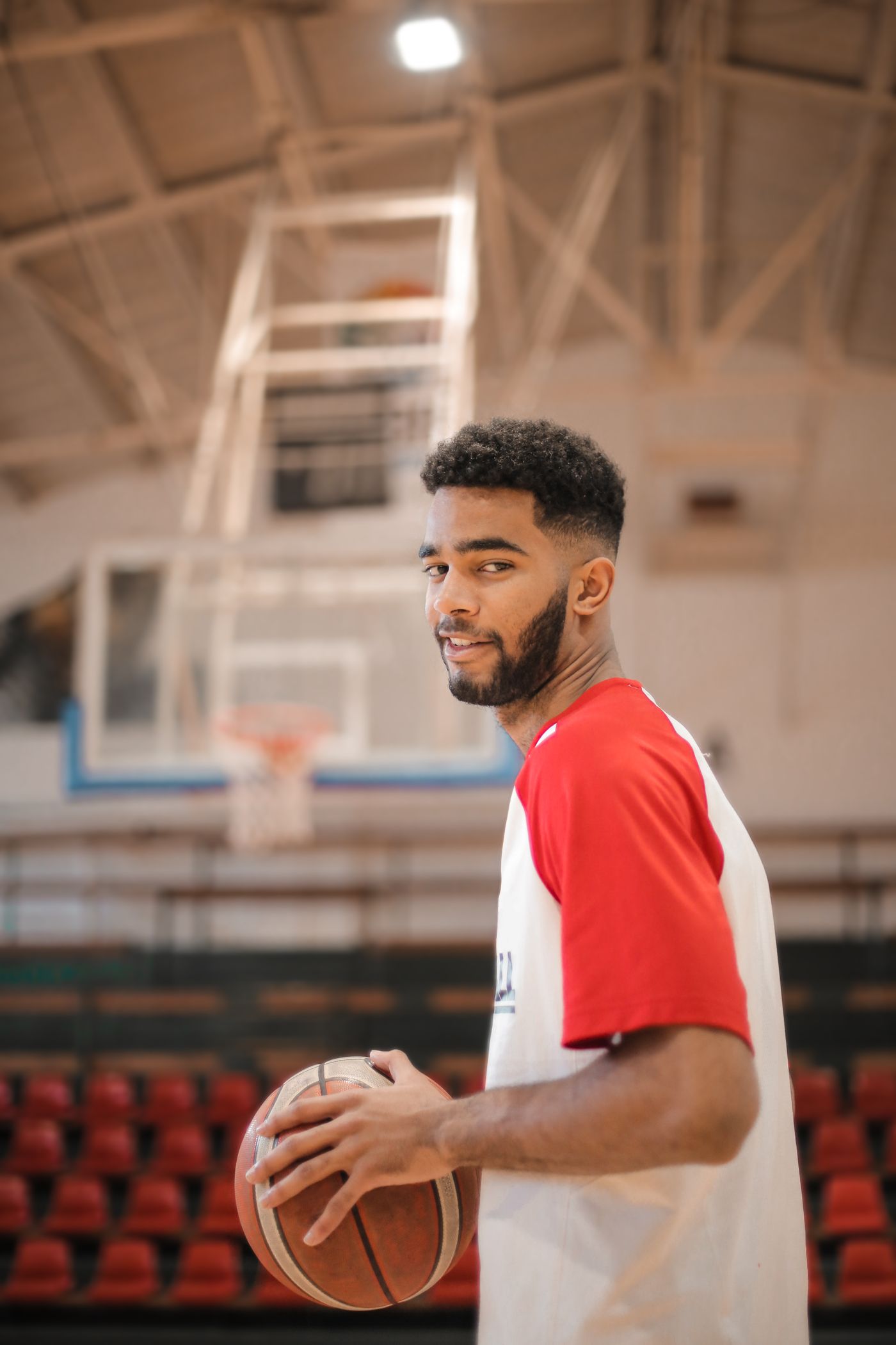 Basketball player holding a ball on an indoor court